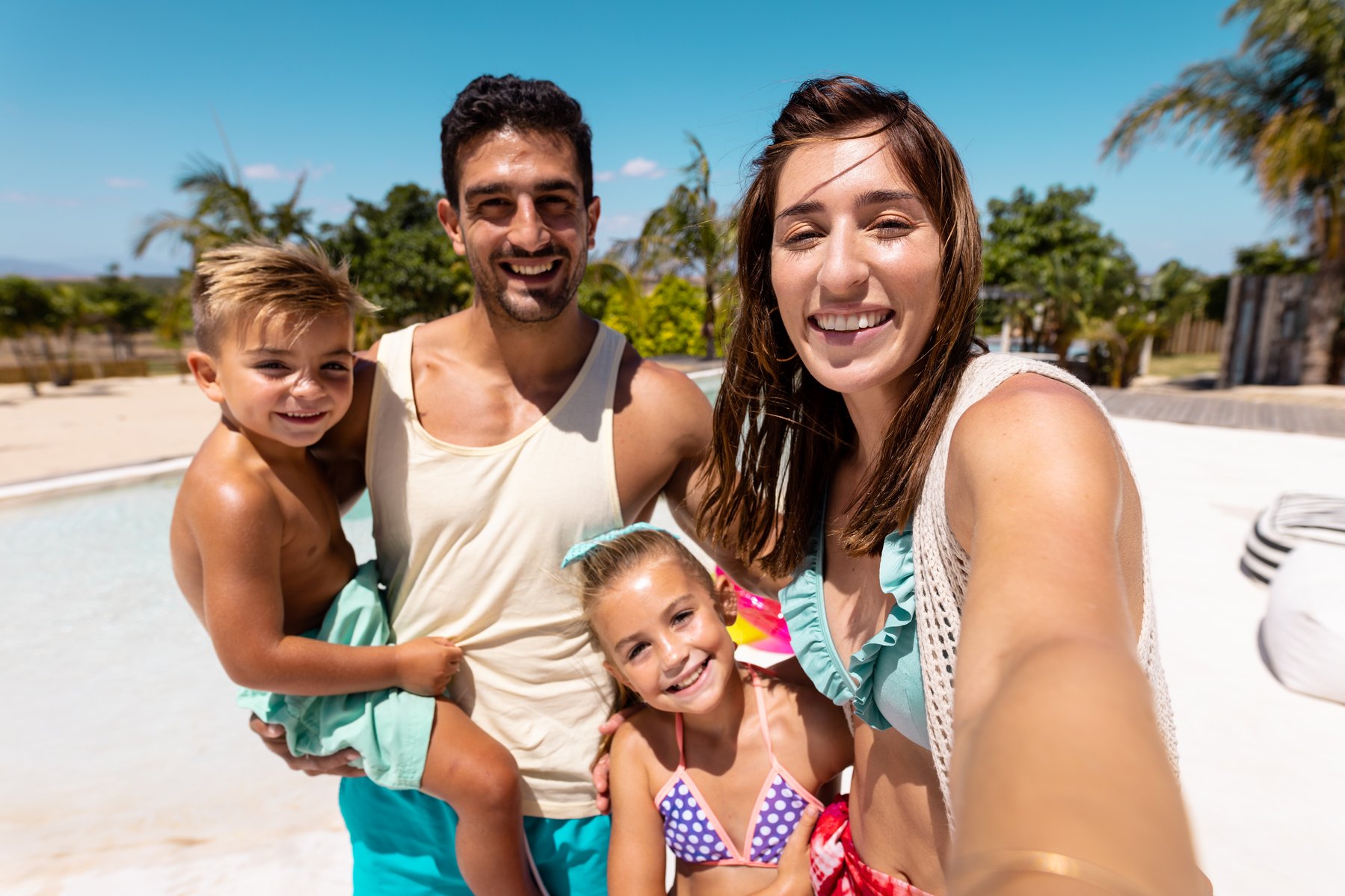 happy-biracial-family-taking-selfie-by-the-swimmin-2023-06-09-17-13-32-utc